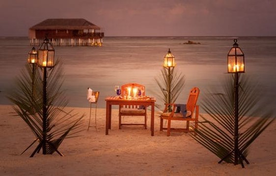 romantic candelit dinner on a beach in the maldives